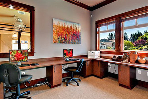 Office room with computer desks, chairs, and nice view of trees outside