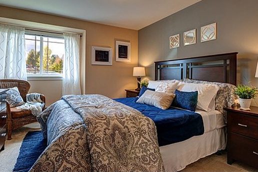 Carpeted bedroom with queen bed, nicely decorated, gray walls
