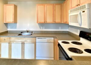 Unit Kitchen, Light brown Cabinetry, White appliances,