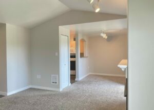 Unit Living Room, Carpet flooring, Linen closet between living room and kitchen, Breakfast bar, Fireplace.