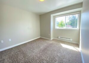 Unit Bedroom, Window, AC vent in bedroom, carpet flooring. Double window on farside wall when entering.
