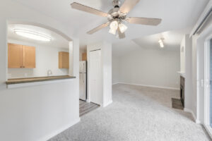 Interior Unit dining area, ceiling fan/light fixture in dining area, breakfast bar attached to kitchen, wood like floors in kitchen area, light brown cabinets in kitchen, stainless steel appliances in kitchen, white walls, neutral toned carpeting.