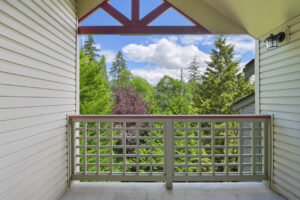 Exterior Unit Patio, View of dense woods, outdoor light fixture, wood railing.
