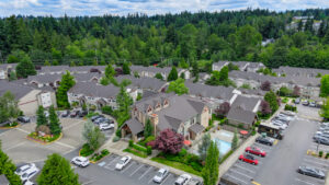 Aerial Exterior of Lodge at peasley canyon community, surrounding areas in shot, dense woods in background, swimming pool, parking lot.