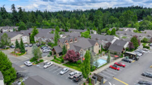 Aerial Exterior of Lodge at peasley canyon community, surrounding areas in shot, dense woods in background, swimming pool, parking lot.