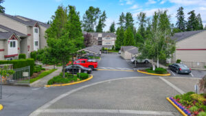 Exterior parking lot, surrounding residential buildings, covered and noncovered parking out front. meticulous landscaping, gated community.